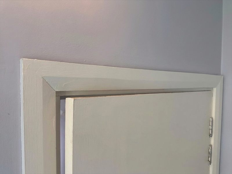 Painted timber architrave installed around a finished door opening